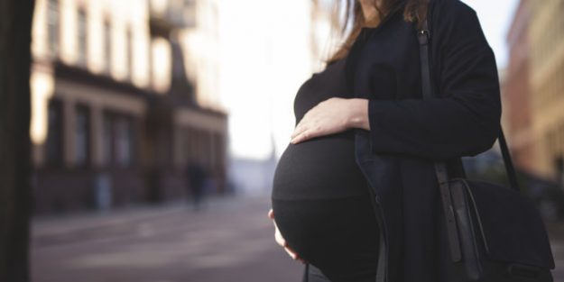 Pregnant woman standing on street